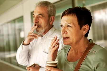 Älterer Mann und ältere Frau rauchen